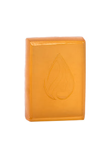 Orange bar of soap with a leaf logo on a white background